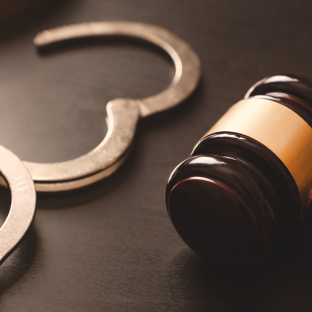 Open handcuff and gavel on desk