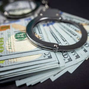 $100 banknotes and handcuffs