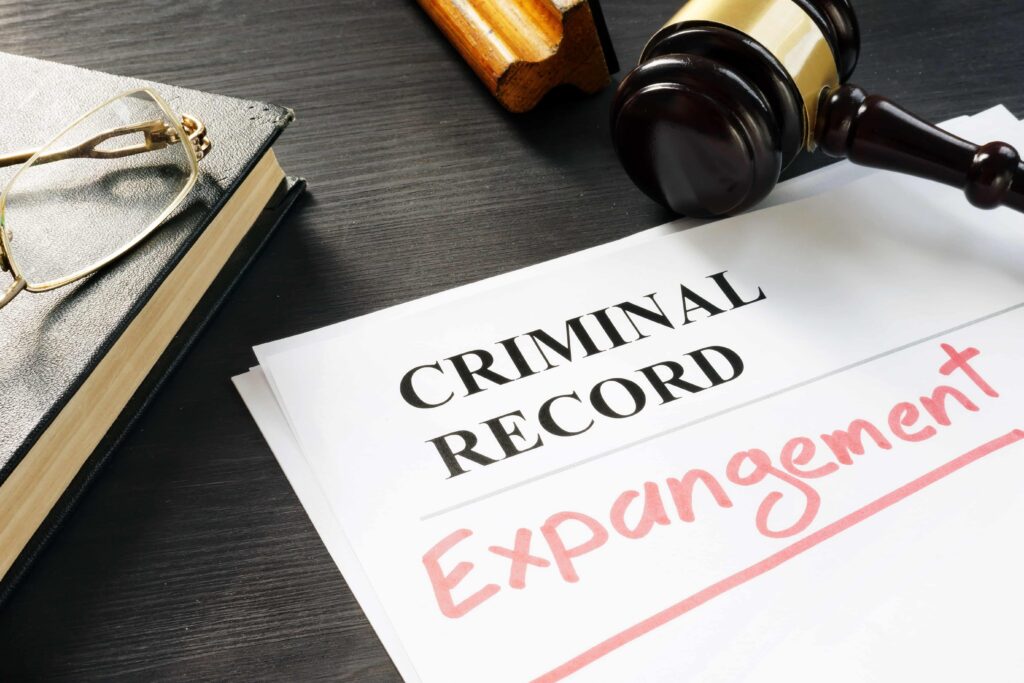 Criminal record expungement document on a desk with a judge&rsquo;s gavel and law book, representing clearing a criminal record and legal expungement services.